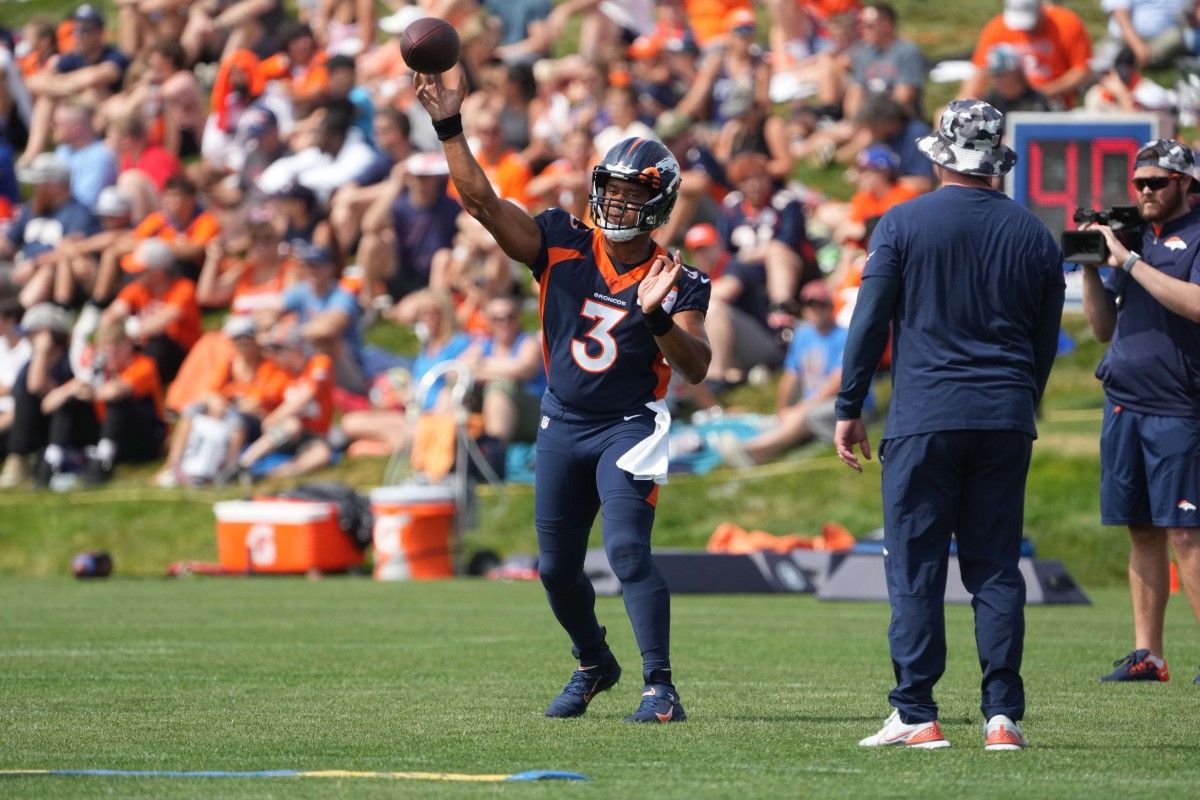 Denver Broncos quarterback Russell Wilson (3) throws in front of head coach Nathaniel Hackett during training camp at the UCHealth Training Center.