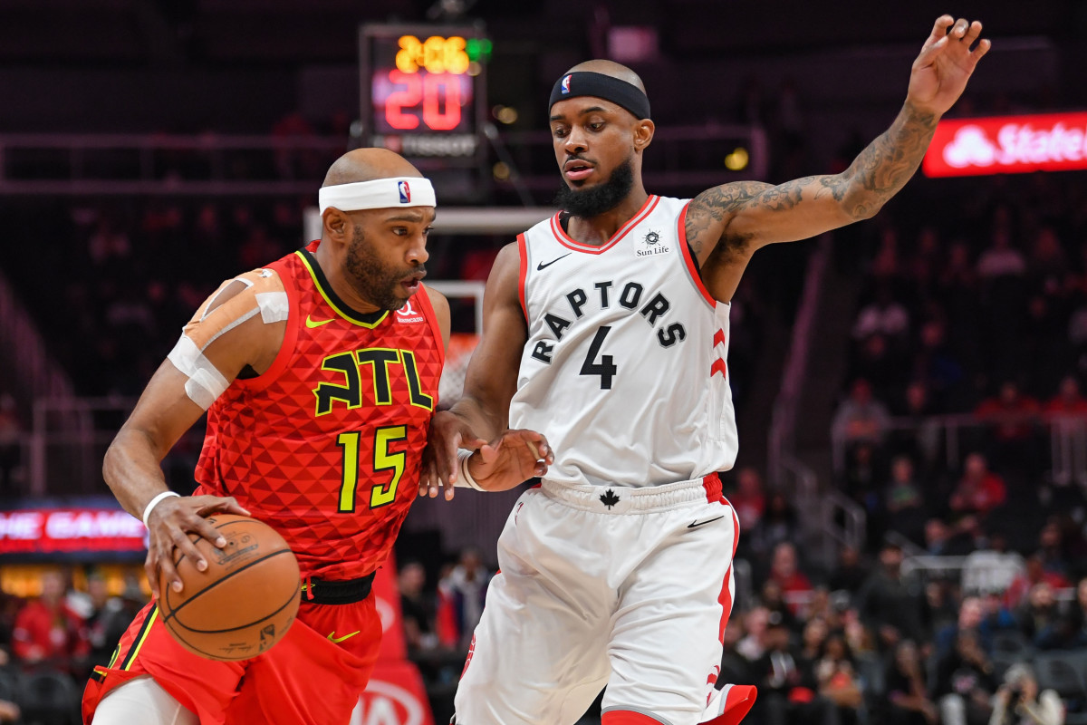 Former NC State guard Lorenzo Brown has played professionally throughout the world. In this photo, Brown is a member of the Toronto Raptors playing in his home state of Georgia and is guarding Vince Carter of the Atlanta Hawks. 