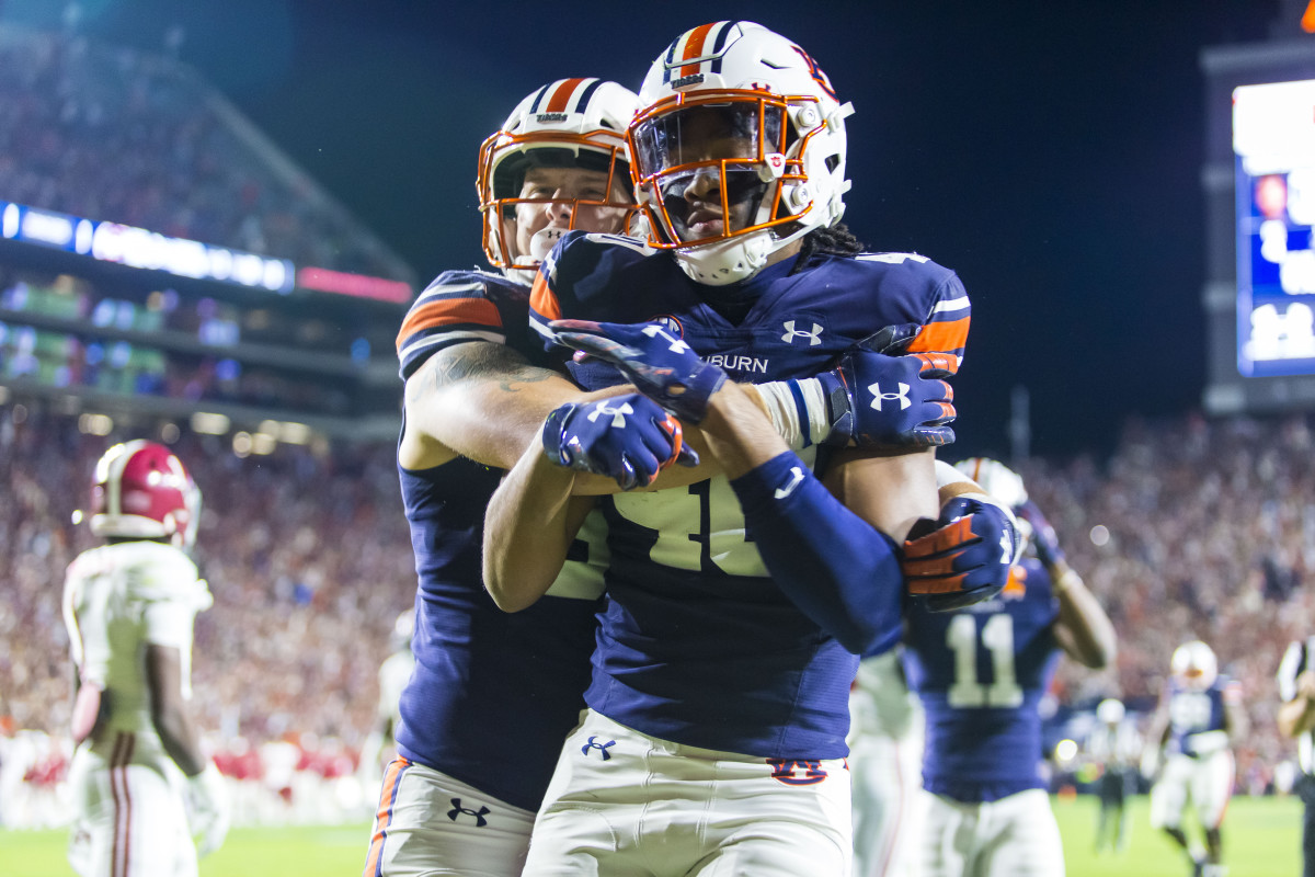 Auburn tight end Luke Deal (86) hugs Auburn tight end Landen King (40) as King celebrates a one-handed touchdown reception against Alabama during the first overtime of an NCAA college football game, Saturday, Nov. 27, 2021, in Auburn, Ala. The touchdown sent the game to a second overtime, a game won in four overtimes by Alabama, 24-22. (AP Photo/Vasha Hunt)