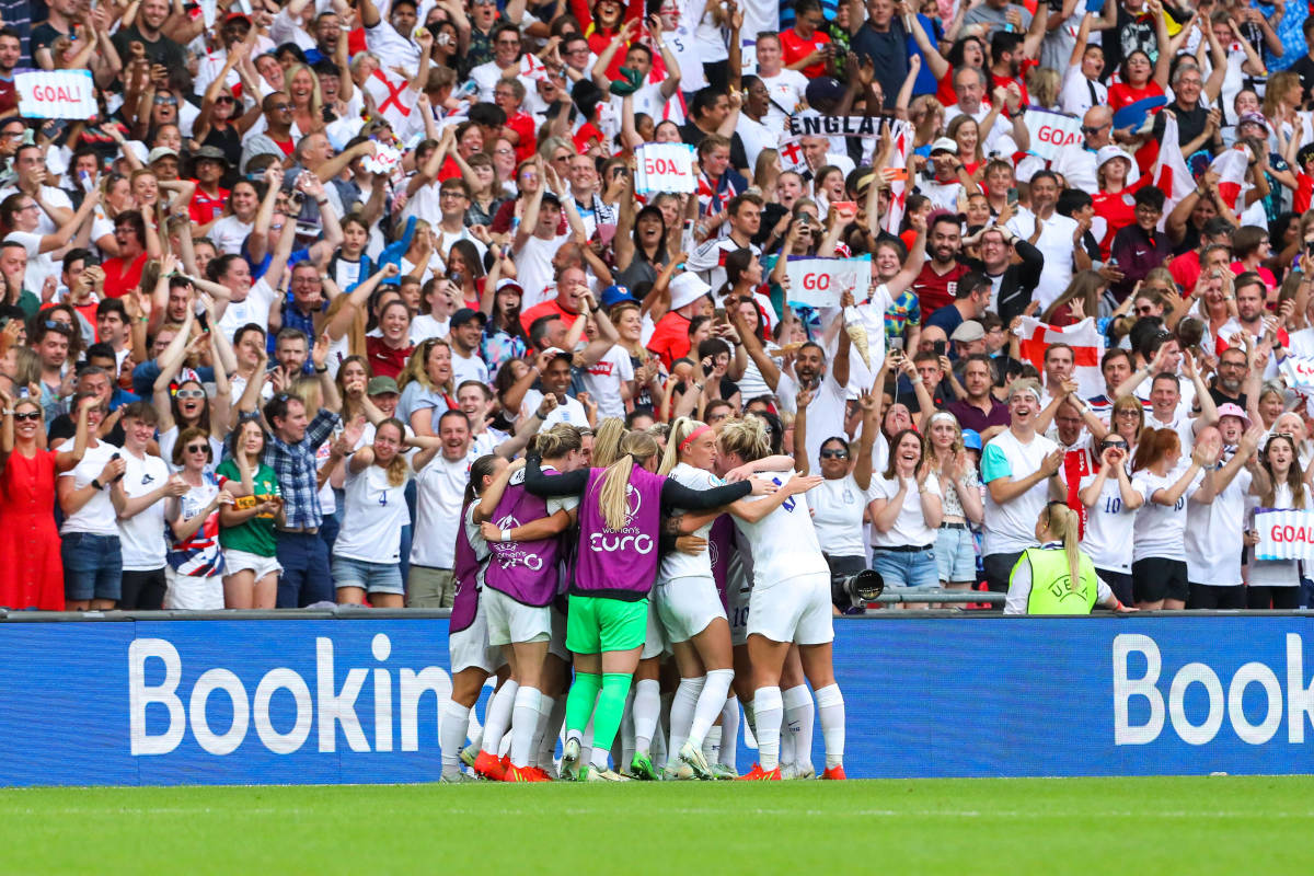 England's players and fans pictured celebrating after Ella Toone's goal against Germany in the final of Euro 2022