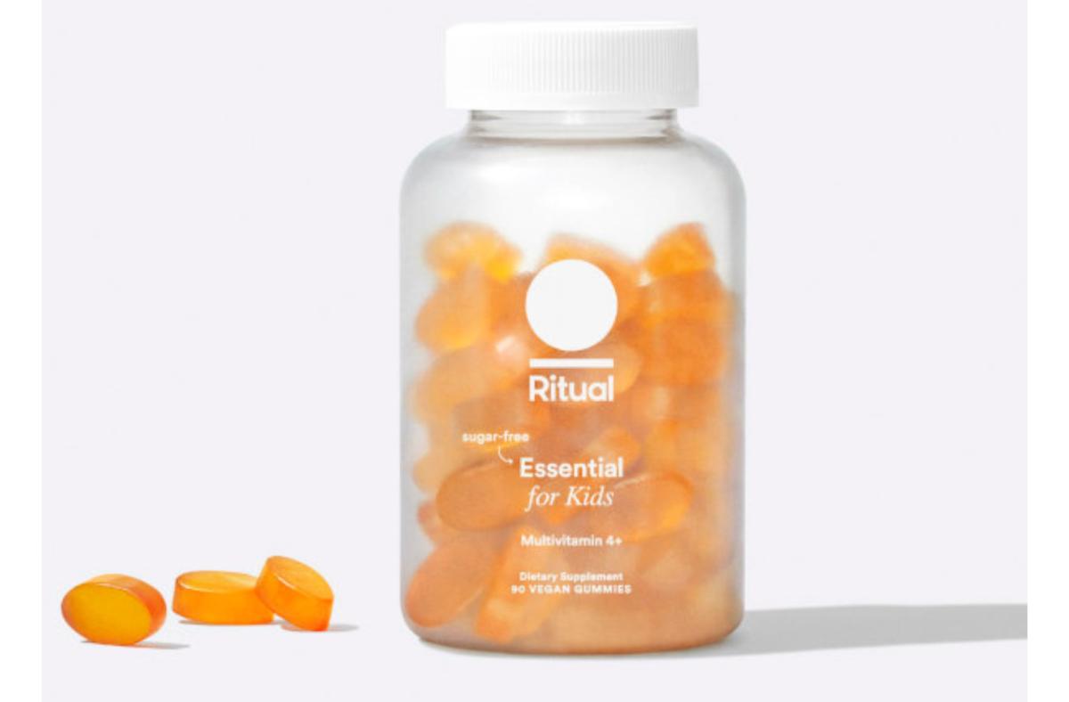 A bottle of Ritual Essential for Kids multivitamin filled with orange gummy multivitamin supplements.