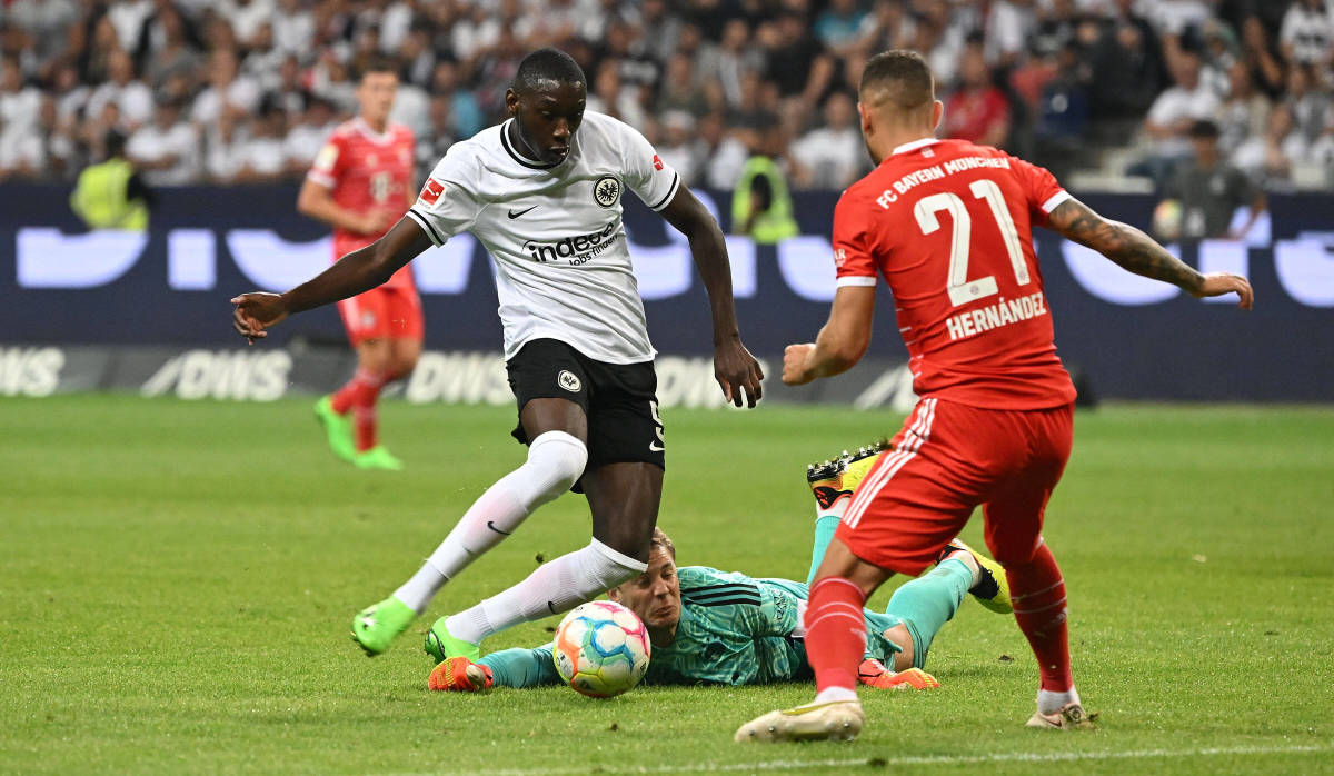 Bayern Munich goalkeeper Manuel Neuer pictured laying on the ground as Randal Kolo Muani shoots to score for Frankfurt in August 2022