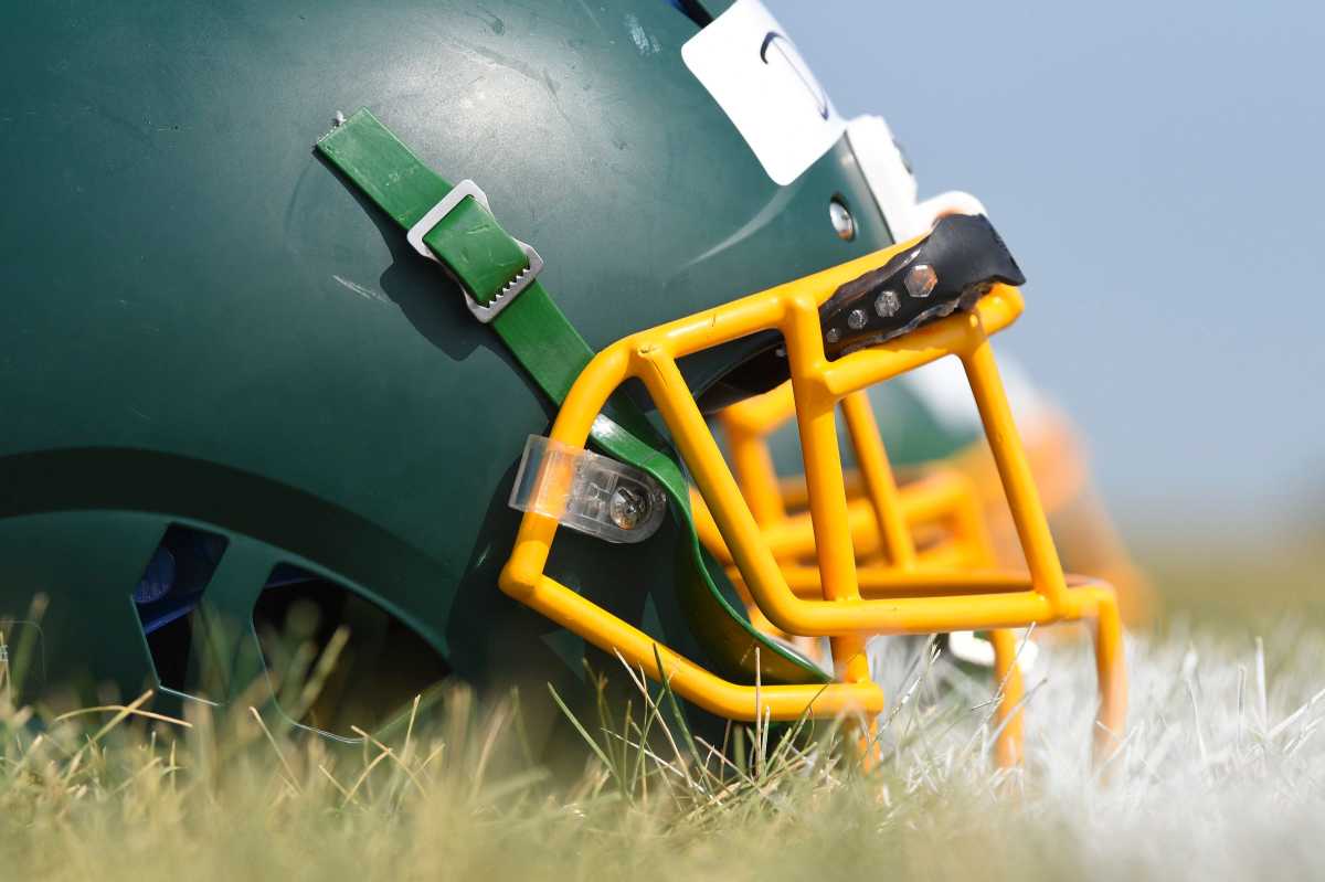 A row of helmets sit on the grass at Sauk Rapids-Rice High School in Minnesota.