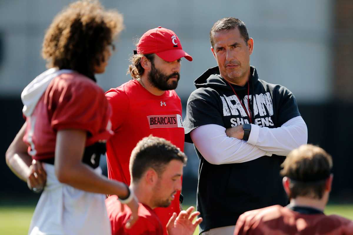 Bearcats head coach Luke Fickell checks in with the quarterbacks during the first day of preseason training camp at the University of Cincinnati s Sheakley Athletic Complex in Cincinnati on Wednesday, Aug. 3, 2022. Bearcats Football Camp
