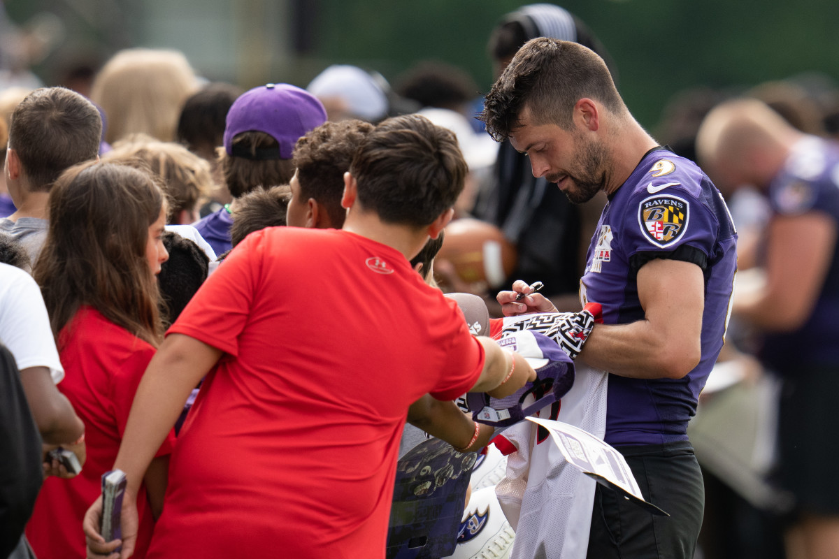Justin Tucker signs autographs at training camp. 