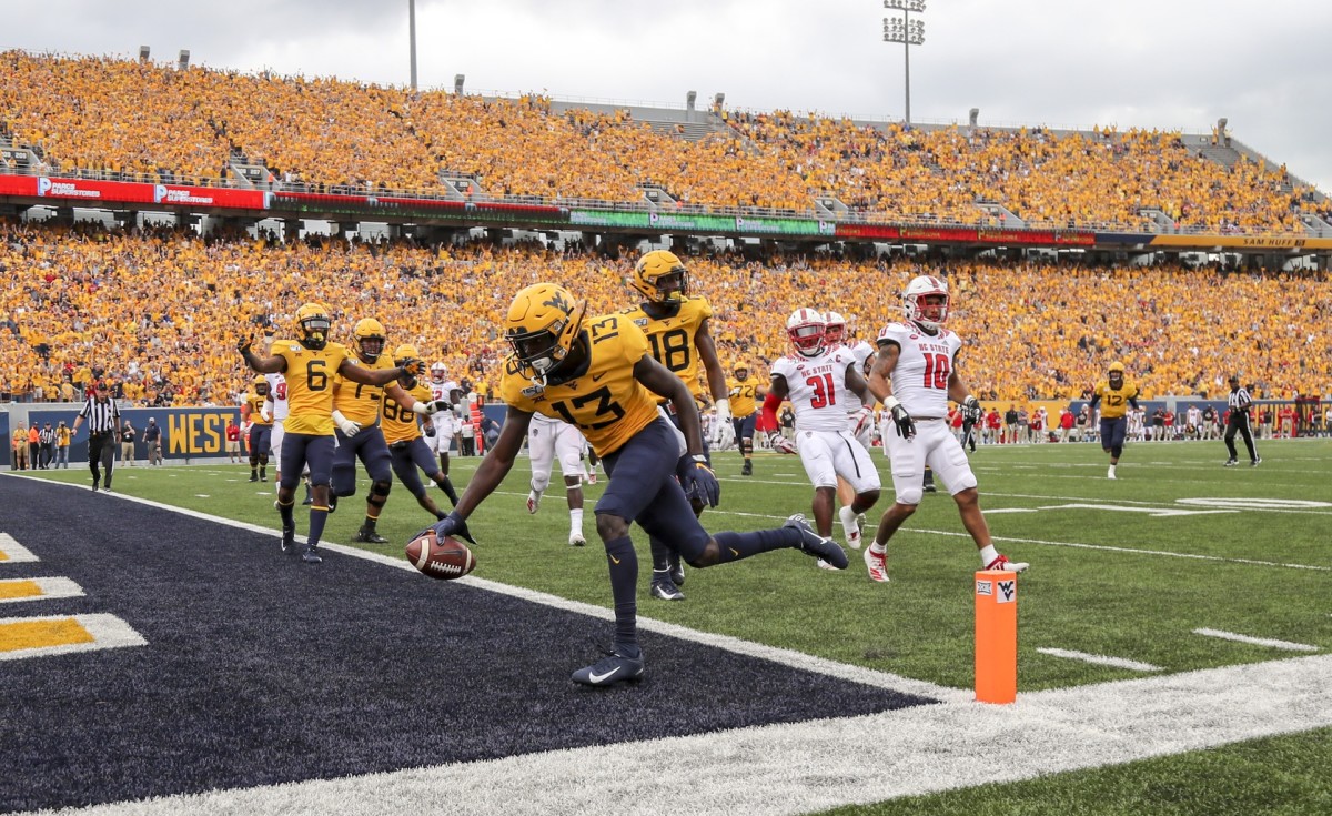 Sep 14, 2019; Morgantown, WV, USA; West Virginia Mountaineers wide receiver Sam James (13) catches a pass and runs for a touchdown during the first quarter against the North Carolina State Wolfpack at Mountaineer Field at Milan Puskar Stadium.