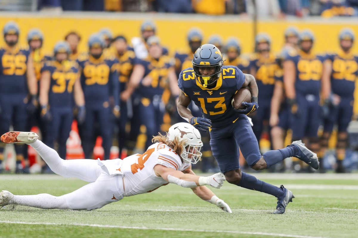 Nov 20, 2021; Morgantown, West Virginia, USA; West Virginia Mountaineers wide receiver Sam James (13) makes a catch and runs for extra yards during the first quarter against the Texas Longhorns at Mountaineer Field at Milan Puskar Stadium.