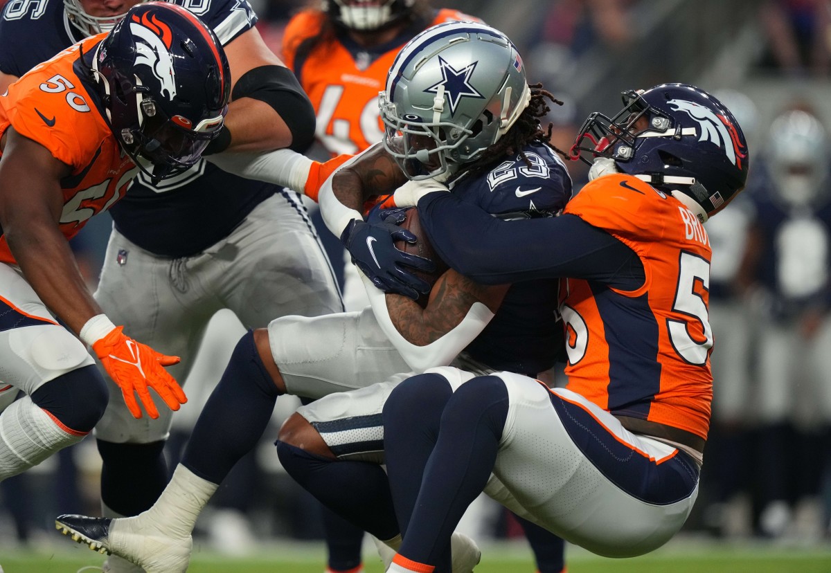 Denver Broncos linebacker Baron Browning (56) tackles Dallas Cowboys running back Rico Dowdle (23) in the first quarter at Empower Field at Mile High.