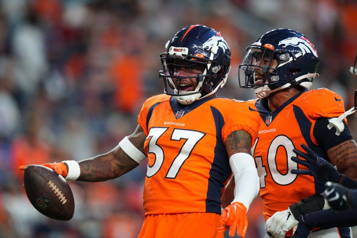Denver Broncos safety P.J. Locke (37) and linebacker Justin Strnad (40) celebrate an interception in the first quarter against the Dallas Cowboys at Empower Field at Mile High.
