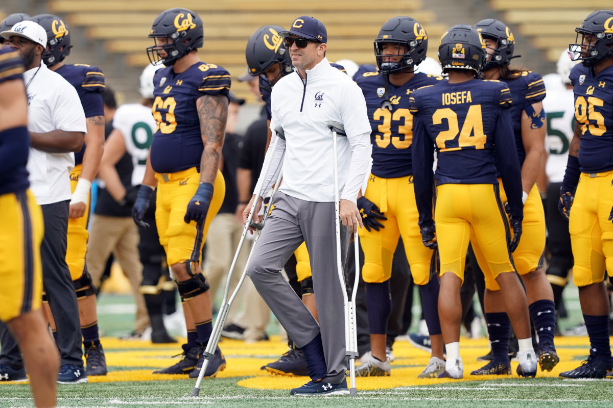 California Golden Bears head coach Justin Wilcox stands on the field with crutches before the game against the Sacramento State Hornets at FTX Field at California Memorial Stadium.