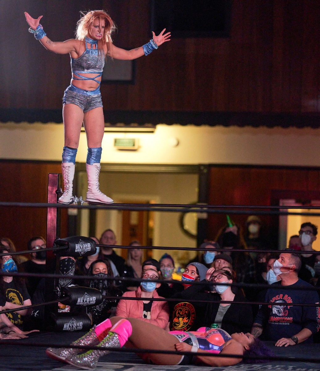 B3CCA prepares to dive off the top rope