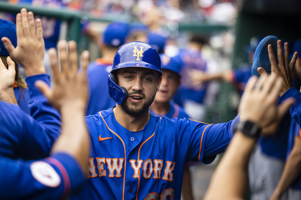 Conforto celebrates in the dugout after scoring a run.