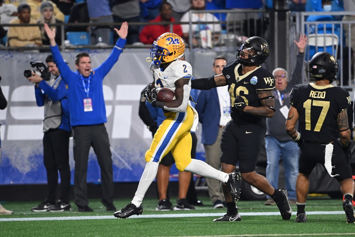 Dec 4, 2021; Charlotte, NC, USA; Pittsburgh Panthers running back Israel Abanikanda (2) scores a touchdown as Wake Forest Demon Deacons linebacker DJ Taylor (46) and defensive back Traveon Redd (17) defend in the third quarter of the ACC championship game at Bank of America Stadium.