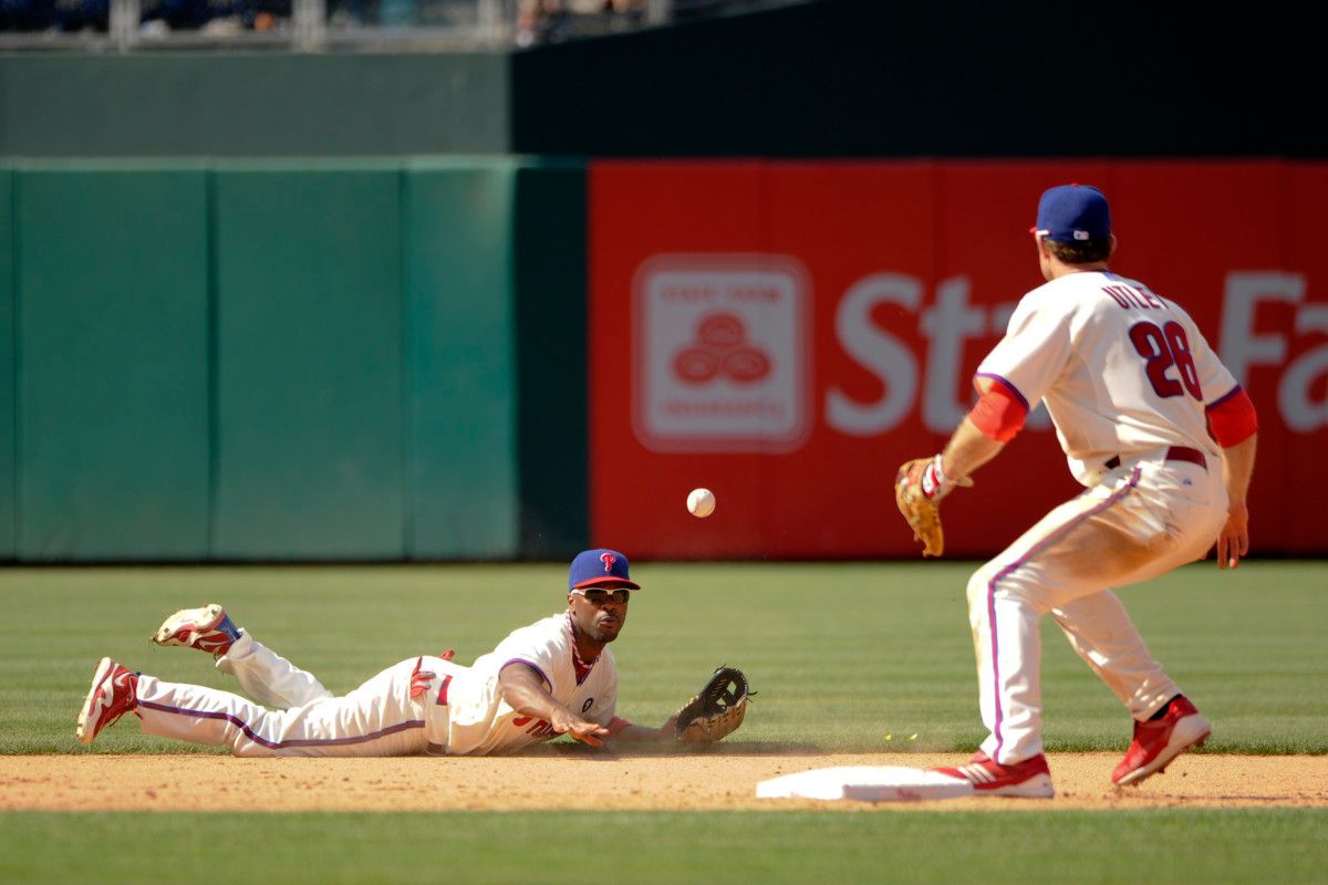 Shortstop Jimmy Rollins tosses the ball to second baseman Chase Utley, securing a Philadelphia Phillies victory.