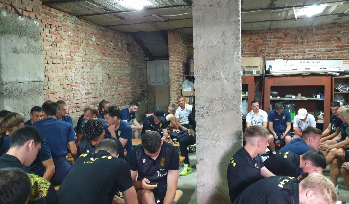 Players from Metalist Kharkiv and Rukh Lviv pictured sitting in a bomb shelter after the start of their Ukrainian Premier League game in August 2022 was delayed by an air raid siren