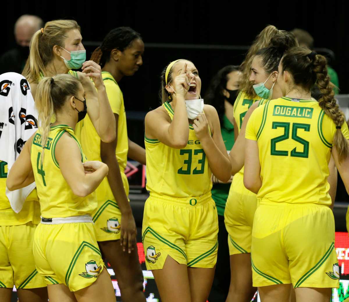 Sydney Parrish points to the score board alongside her teammates after the Ducks dispatched Utah 85-43