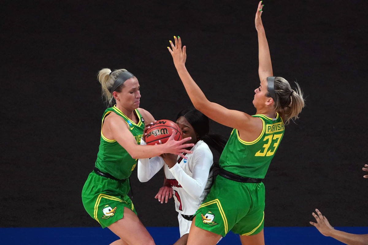 Sydney Parrish and Maddie Scherr defend against Louisville Cardinals guard Dana Evans in the first quarter in the Sweet Sixteen of the 2021 Women's NCAA Tournament at Alamodome.