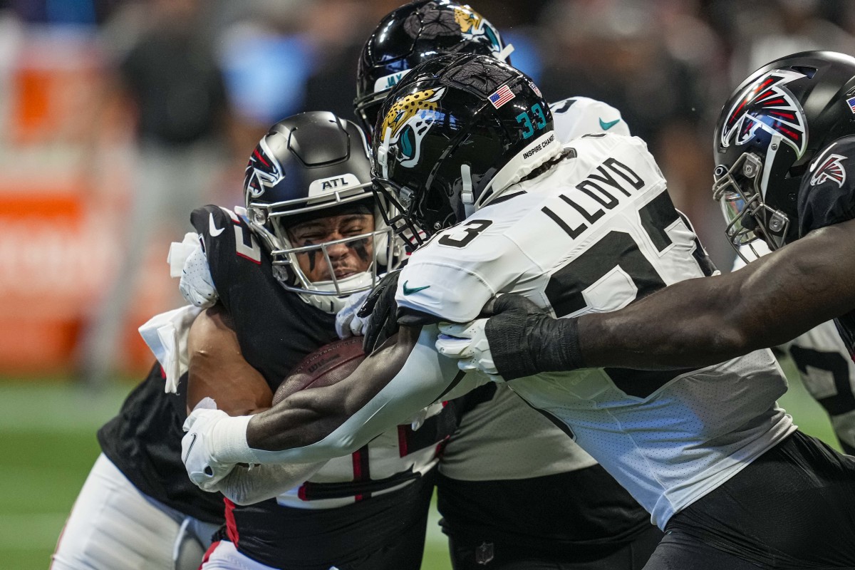 Atlanta Falcons running back Tyler Allgeier (25) is hit by Jacksonville Jaguars linebacker Devin Lloyd (33) during the first quarter at Mercedes-Benz Stadium.