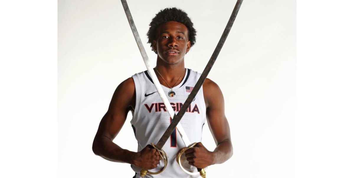 Four-star shooting guard Davin Cosby poses with two sabers in a UVA uniform during his official visit to the Virginia men's basketball program.