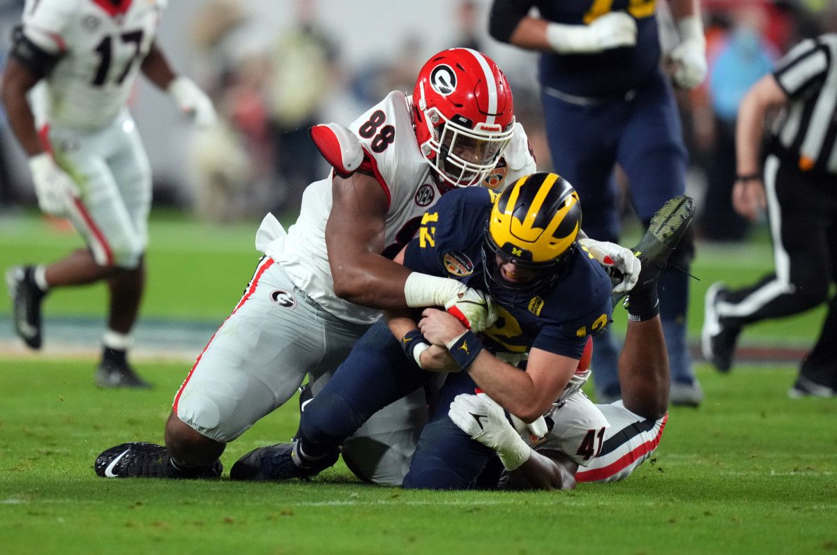 Jalen Carter wraps up Michigan quarterback Cade McNamara during the Orange Bowl.