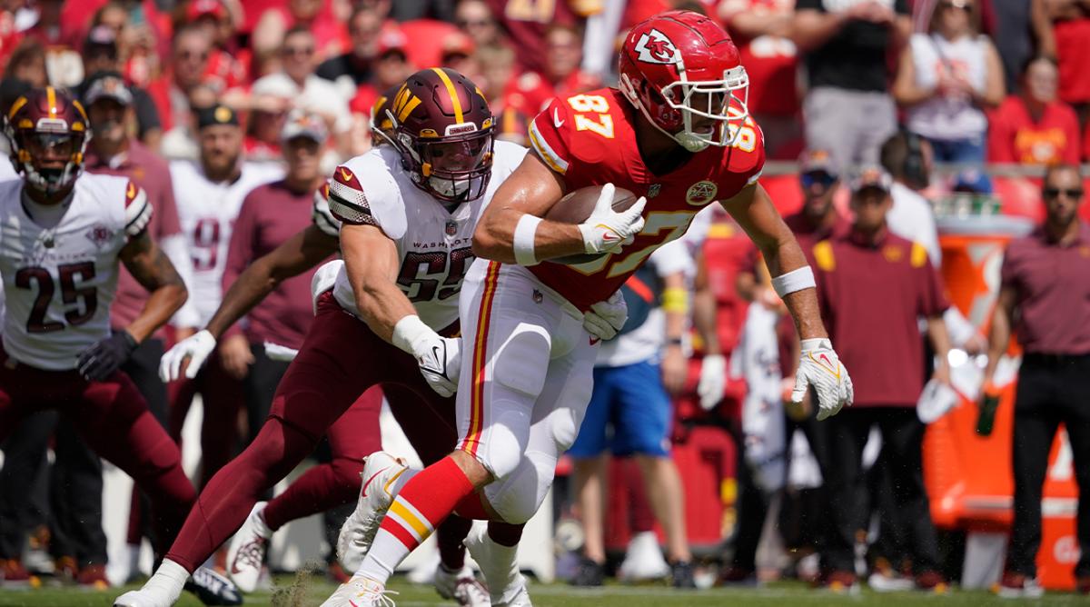 Kansas City Chiefs tight end Travis Kelce, right, runs with the ball as Washington Commanders linebacker Cole Holcomb defends during the first half of an NFL preseason football game Saturday, Aug. 20, 2022, in Kansas City, Mo.