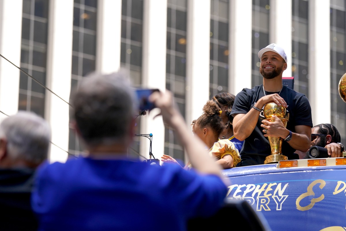 Jun 20, 2022; San Francisco, CA, USA; Golden State Warriors guard Stephen Curry smiles with the NBA Finals Most Valuable Player Award trophy during the Warriors championship parade in downtown San Francisco. Mandatory Credit: Cary Edmondson-USA TODAY Sports
