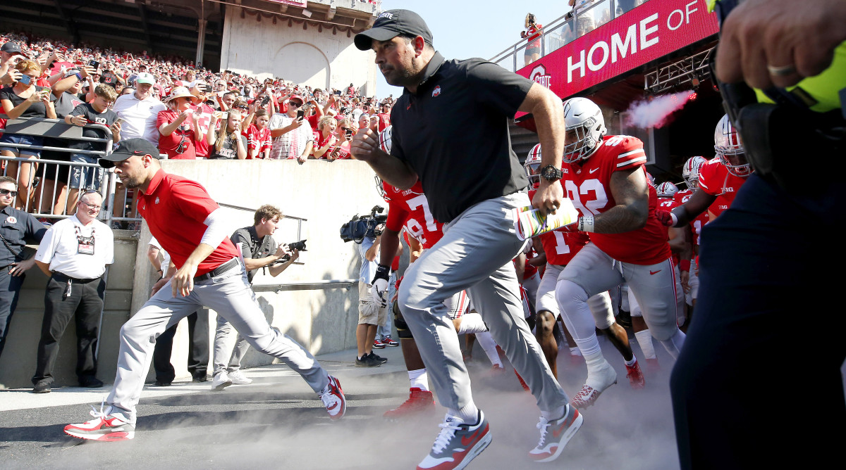 Ohio State coach Ryan Day takes the team onto the field before a game against Tulsa.