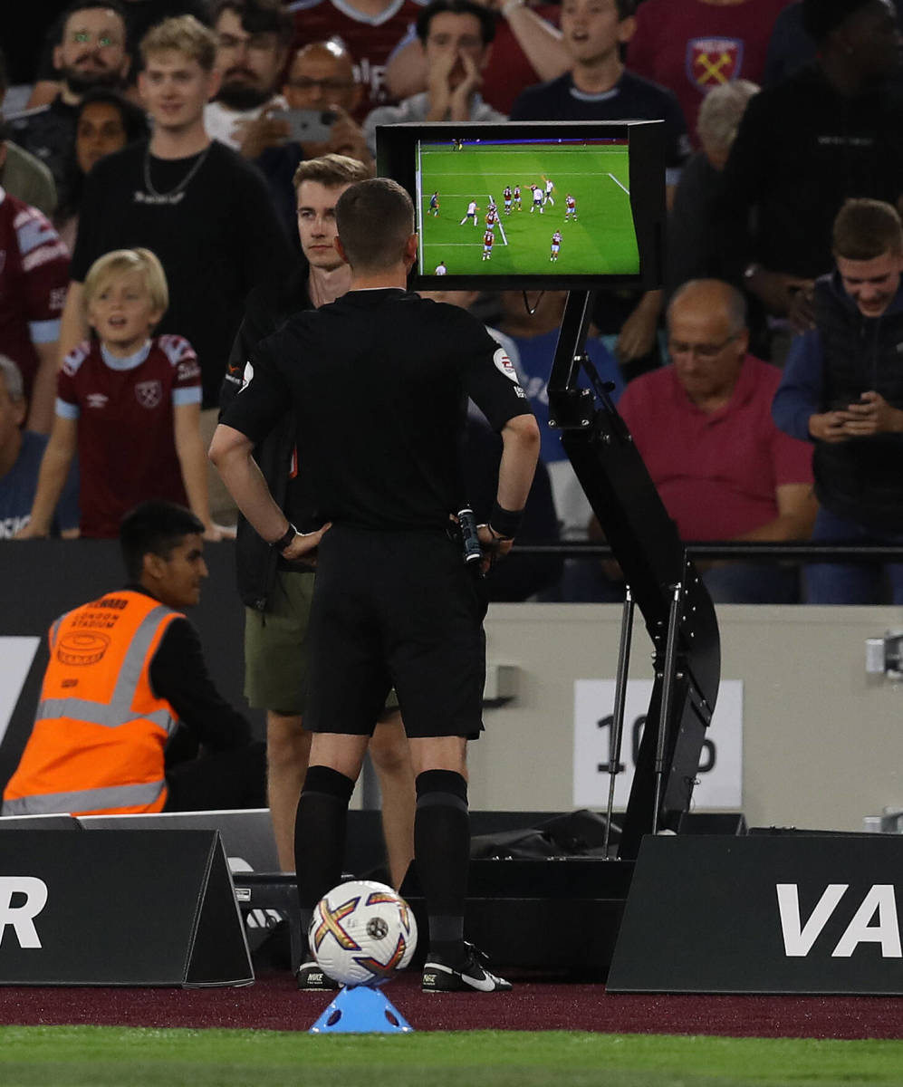 Referee Peter Bankes pictured looking at a pitchside monitor during West Ham's 1-1 draw with Tottenham in August 2022