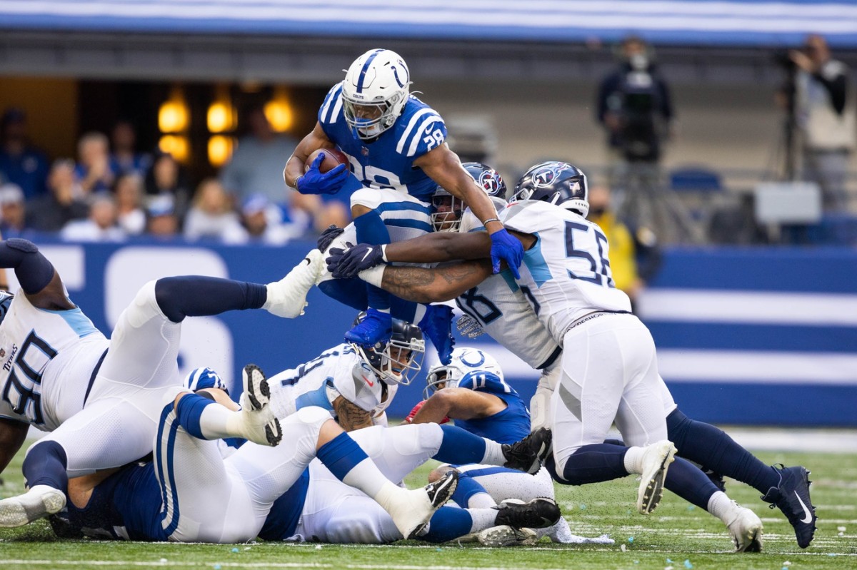 Indianapolis Colts running back Jonathan Taylor (28) runs the ball while Tennessee Titans linebackers Harold Landry (58) and Monty Rice (56) defend. Mandatory Credit: Trevor Ruszkowski-USA TODAY