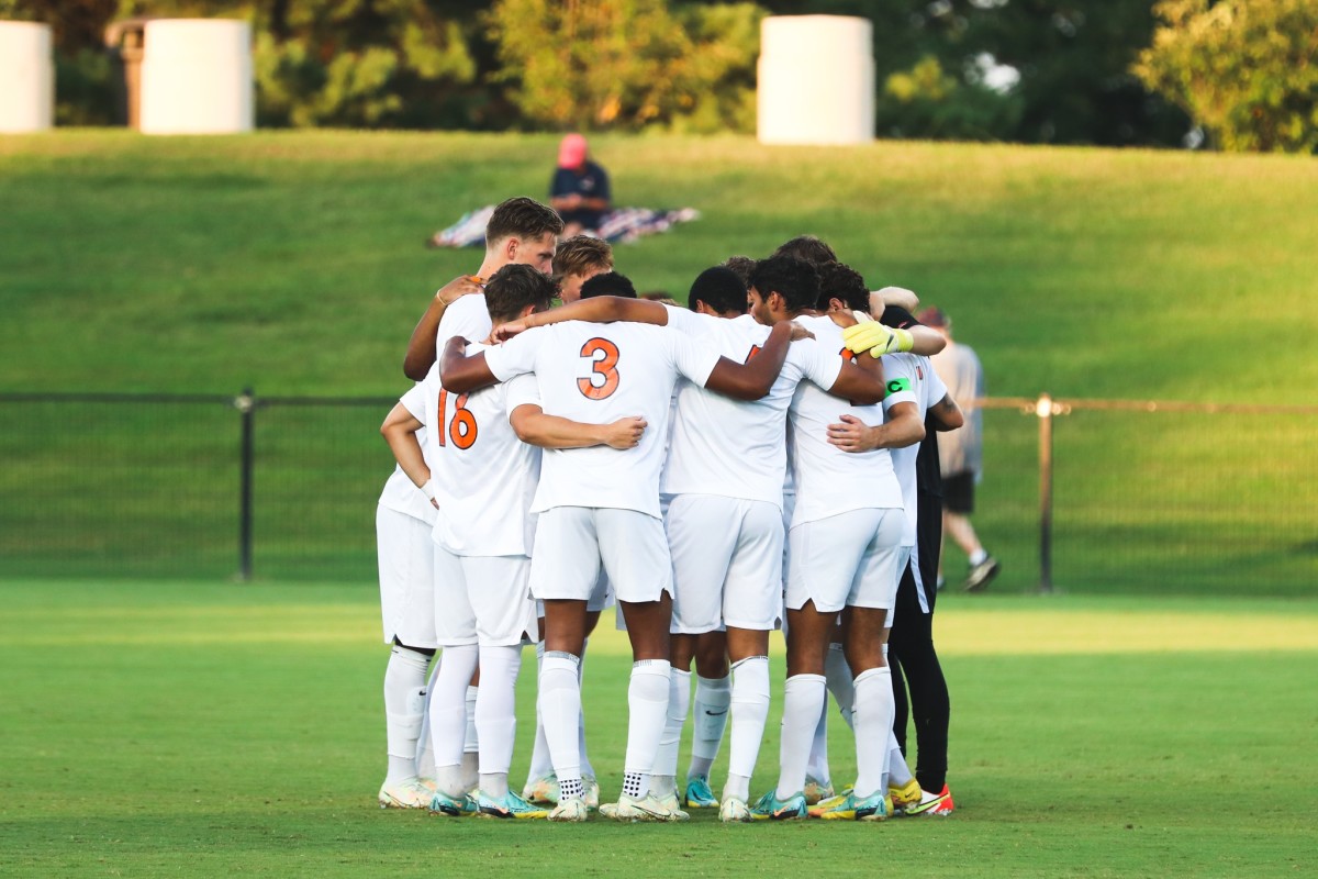 The Virginia men's soccer team huddles before a match.