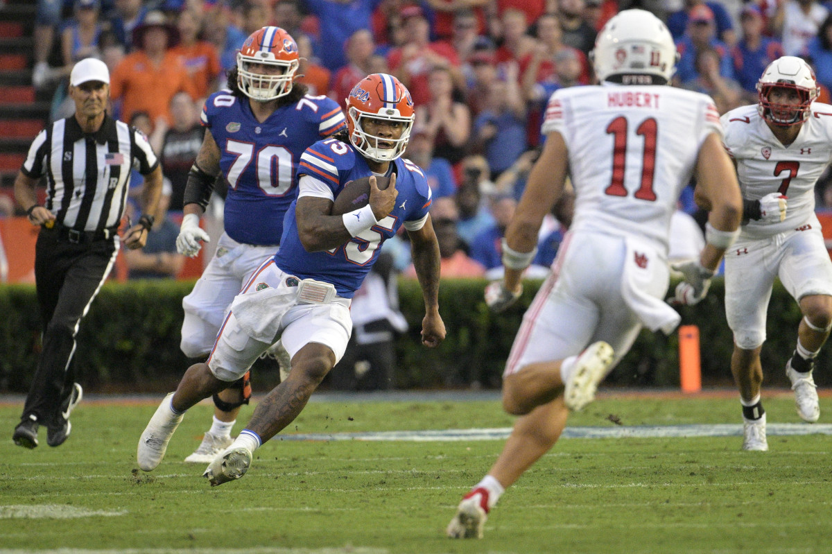 Florida quarterback Anthony Richardson (15) scrambles for yardage in front of Utah defensive end Van Fillinger (7) and safety R.J. Hubert (11) during the first half of an NCAA college football game, Saturday, Sept. 3, 2022, in Gainesville, Fla. (AP Photo/Phelan M. Ebenhack)