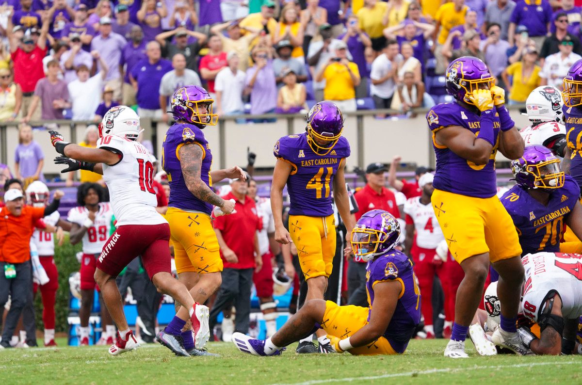 East Carolina Pirates punter Luke Larsen (12), linebacker Eric Doctor (44) and tight end D'Angelo McKinnie (84) react to place kicker Owen Daffer (41) missed field goal attempt at the end of the game against the North Carolina State Wolfpack at Dowdy-Ficklen Stadium.