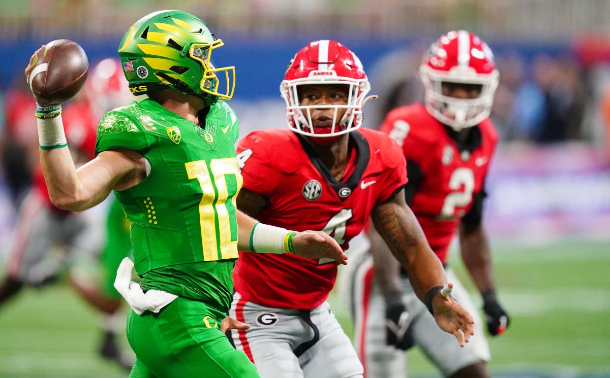 Oregon Ducks quarterback Bo Nix (10) scrambles out to pass against the Georgia Bulldogs during the third quarter of the Chick-fil-A kickoff game at Mercedes-Benz Stadium.