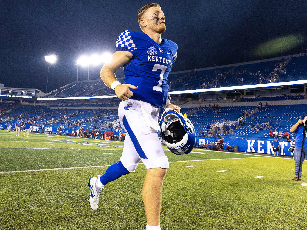 Will Levis runs on the field while holding a helmet