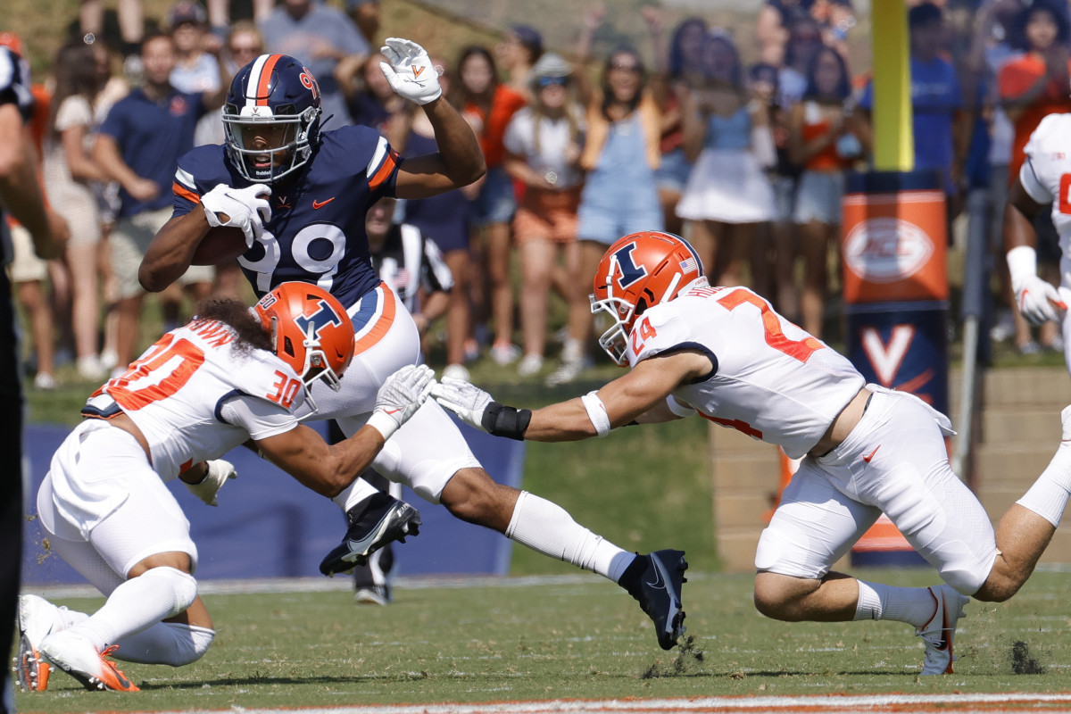Virginia Cavaliers quarterback Keytaon Thompson (99) runs with the ball as Illinois Fighting Illini defensive back Sydney Brown (30) attempts the tackle in the first quarter at Scott Stadium.