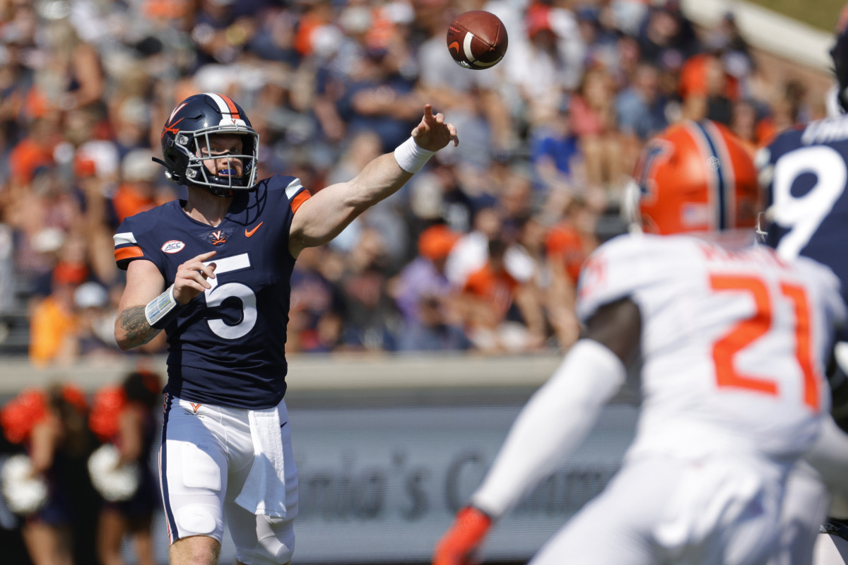 Virginia Cavaliers quarterback Brennan Armstrong (5) passes the ball as Illinois Fighting Illini defensive back Jartavius Martin (21) watches in the first quarter at Scott Stadium.