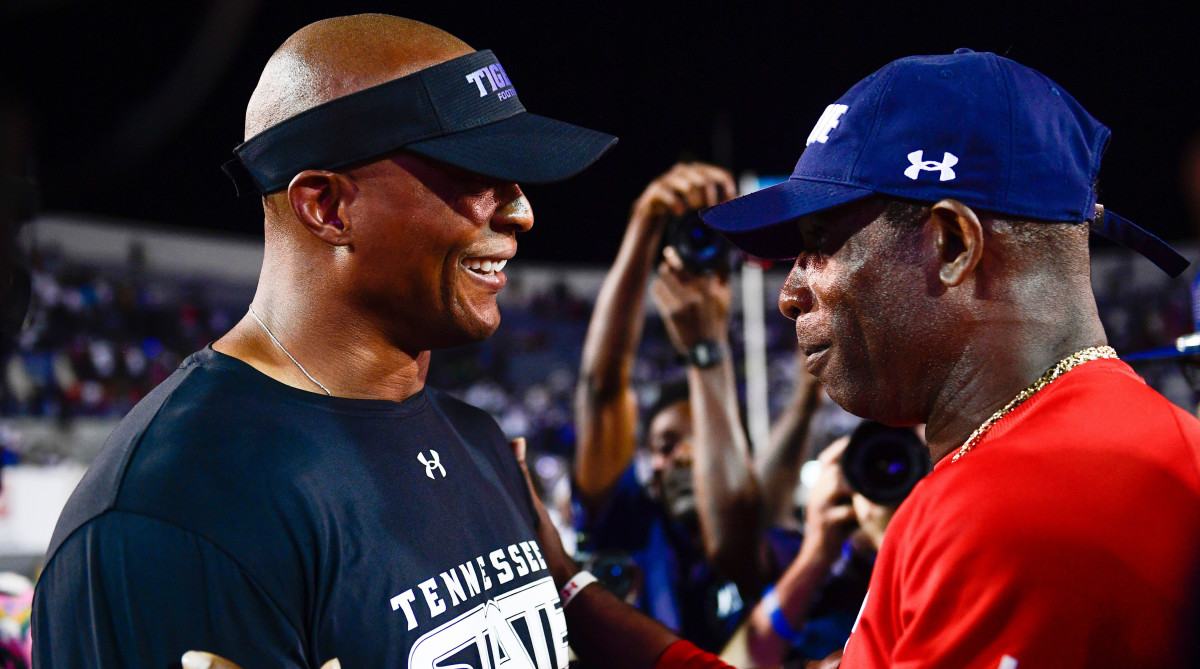 Eddie George and Deion Sanders meet after the game.