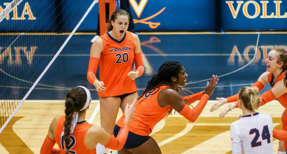 The Virginia Cavaliers volleyball team celebrates after a point against the Charlotte 49ers.