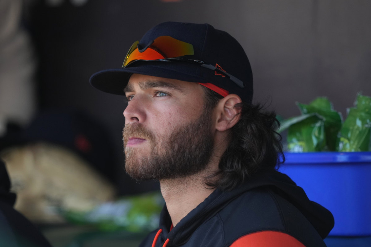 SF Giants shortstop Brandon Crawford looks off the distance while sitting in the dugout.