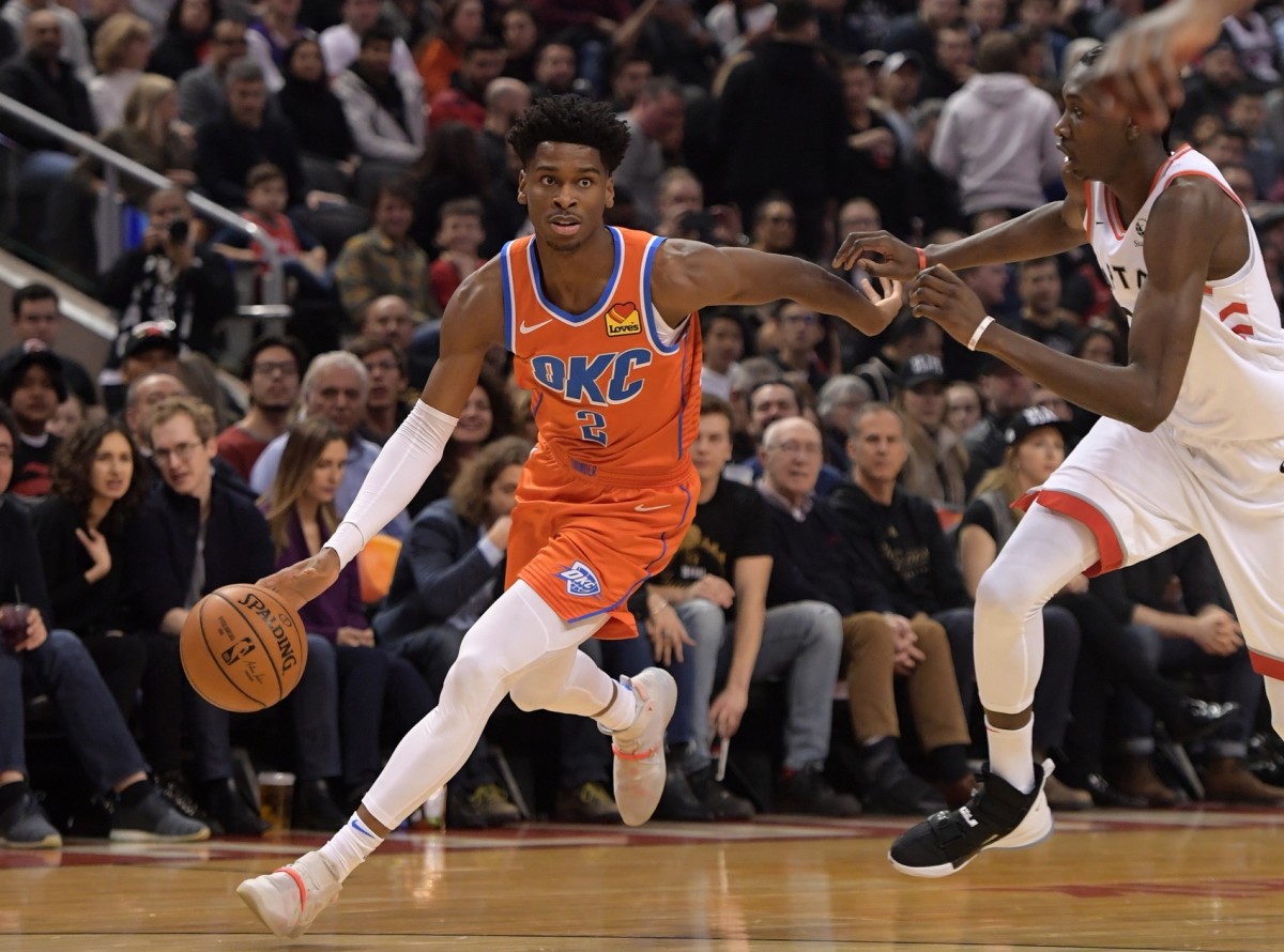 Oklahoma City Thunder guard Shai Gilgeous-Alexander (2) tries to dribble past Toronto Raptors forward Oshae Brissett (12) in the first half at Scotiabank Arena