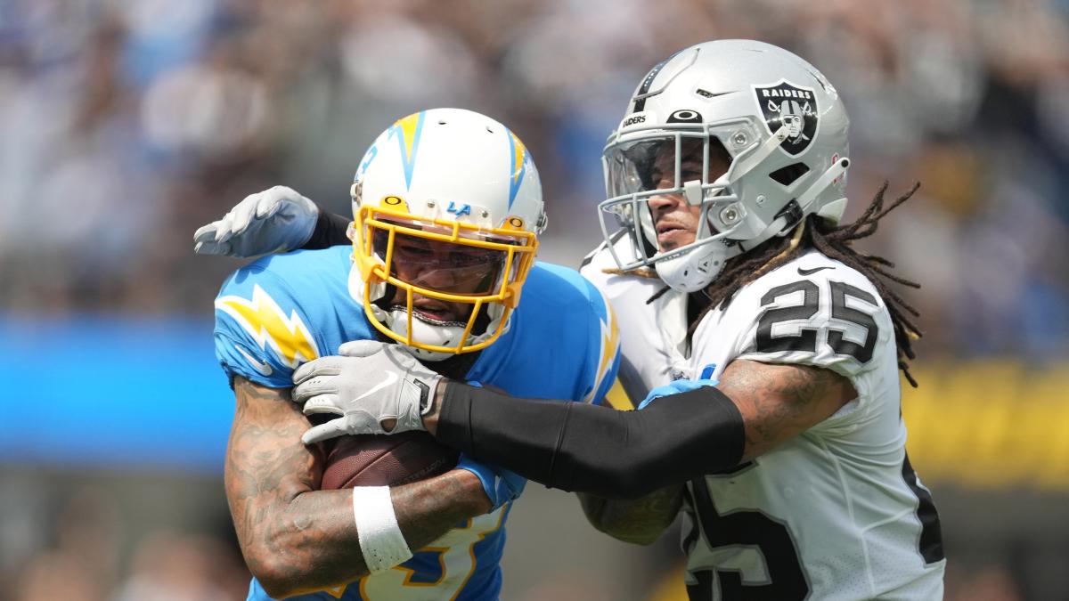 Sep 11, 2022; Inglewood, California, USA; Los Angeles Chargers wide receiver Keenan Allen (13) tries to break free from the grasp of Las Vegas Raiders safety Tre'von Moehrig (25) in the first half at SoFi Stadium.