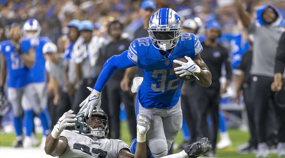 Lions running back D'Andre Swift (32) breaks a tackle attempt from Eagles defensive tackle Javon Hargrave (97) in the second half at Ford Field.