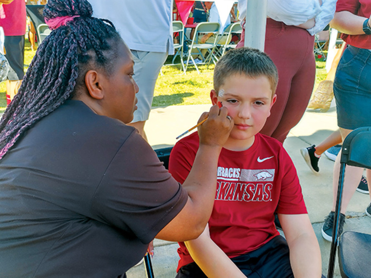 A young Razorback fans puts on the war paint as he prepares to watch his first ever Arkansas football game in person.