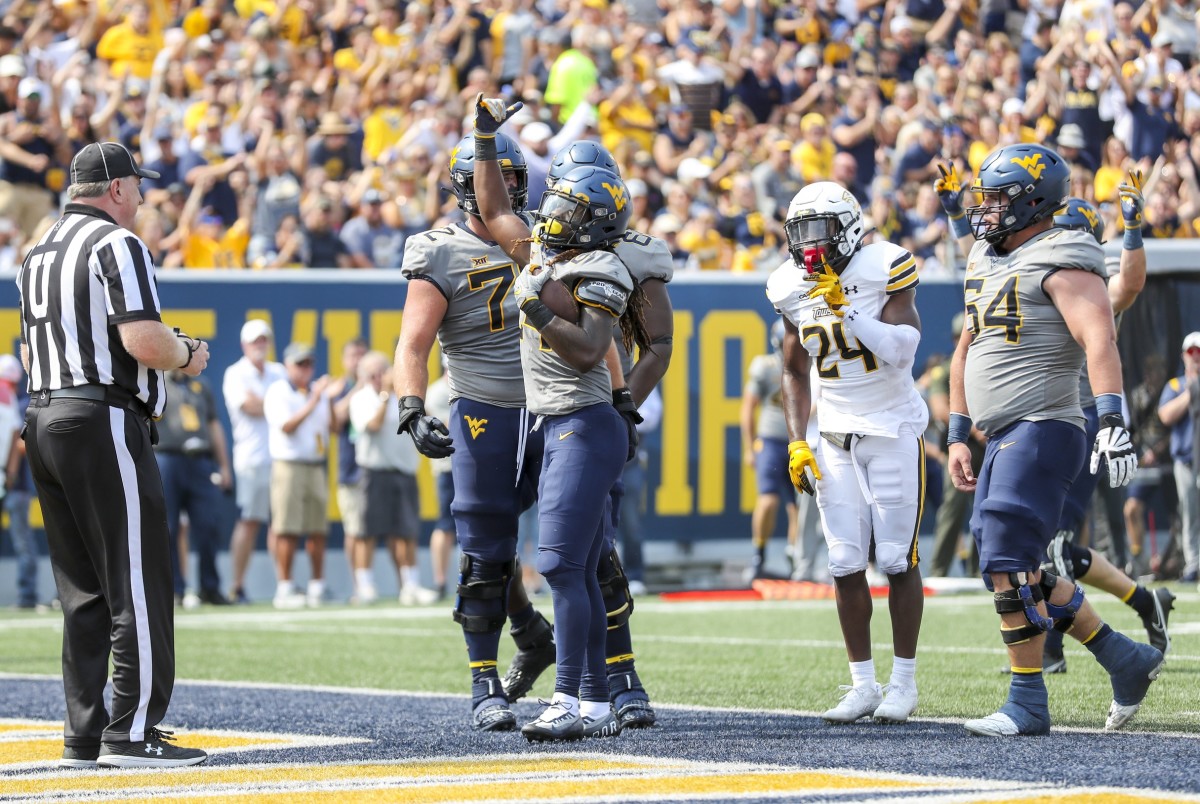 Sep 17, 2022; Morgantown, West Virginia, USA; West Virginia Mountaineers running back Tony Mathis Jr. (24) celebrates after running for a touchdown during the first quarter against the Towson Tigers at Mountaineer Field at Milan Puskar Stadium.