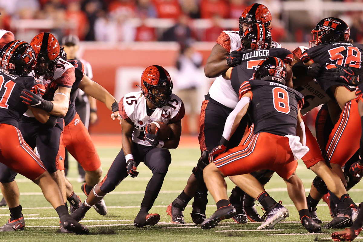 San Diego State Aztecs running back Jordan Byrd (15) runs the ball against Utah Utes safety Cole Bishop (8) in the second quarter at Rice-Eccles Stadium.