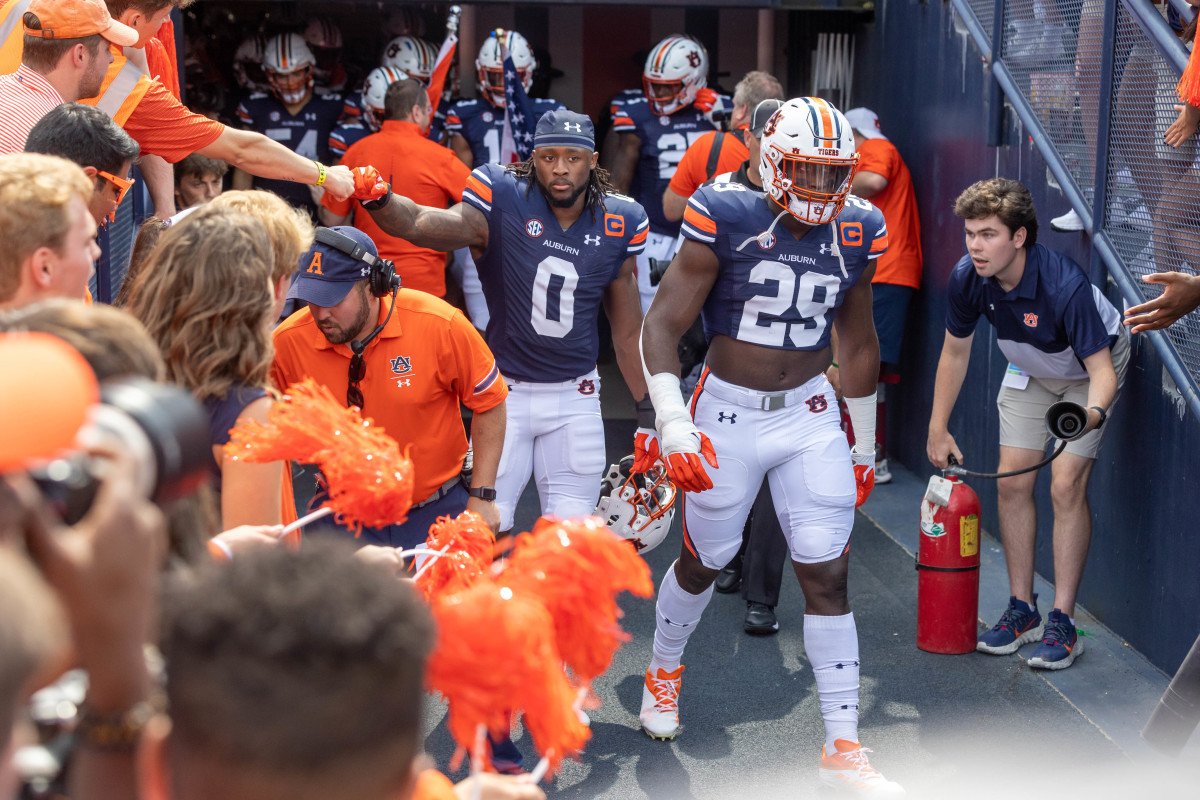 Owen Pappoe and Derick Hall leading the Auburn football team on the field vs Penn State.