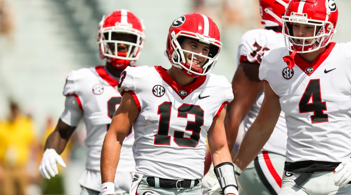 Georgia Bulldogs quarterback Stetson Bennett (13) and Georgia Bulldogs tight end Oscar Delp (4) celebrate a touchdown run by Bennett during the second half of a game against South Carolina.