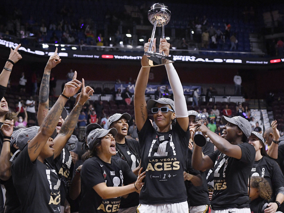 Aces’ A’ja Wilson holds up the championship trophy as she celebrates with her team after beating the Sun in the WNBA Finals.