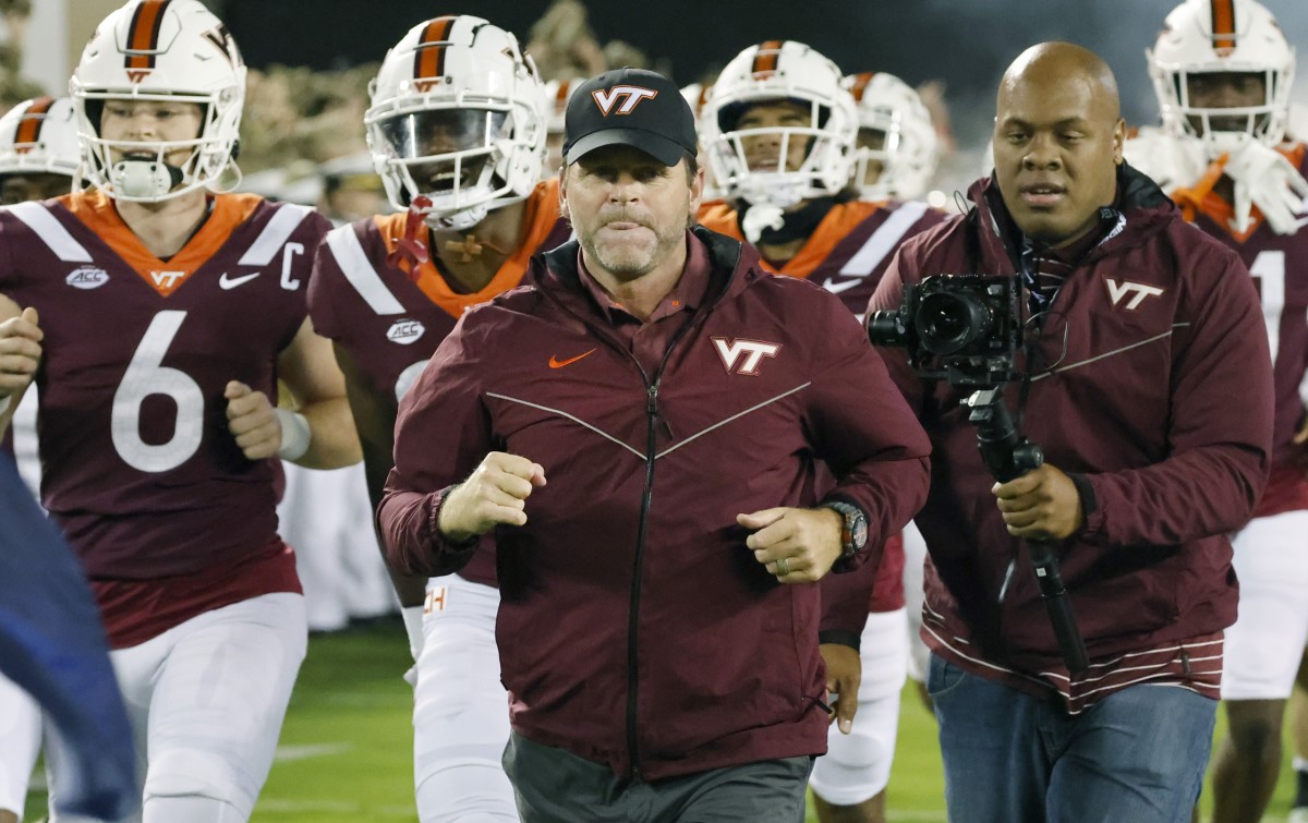 Sep 10, 2022; Blacksburg, Virginia, USA; Virginia Tech Hokies head coach Brent Pry leads his team onto the field along with quarterback Grant Wells (6) before the game against the Boston College Eagles at Lane Stadium.