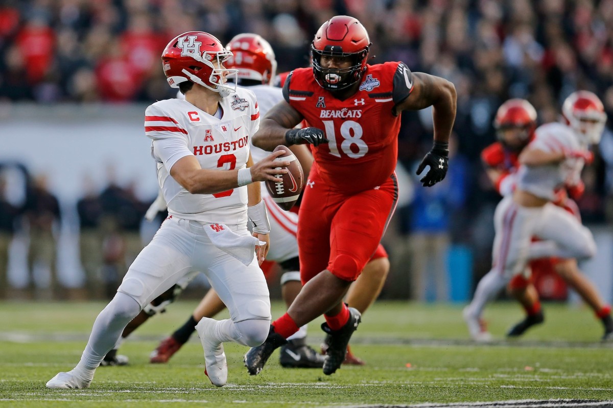Cincinnati Bearcats defensive lineman Jowon Briggs (18) chases Houston Cougars quarterback Clayton Tune (3) in the first quarter of the American Athletic Conference Championship football game between the Cincinnati Bearcats and the Houston Cougars at Nippert Stadium in Cincinnati on Saturday, Dec. 4, 2021.